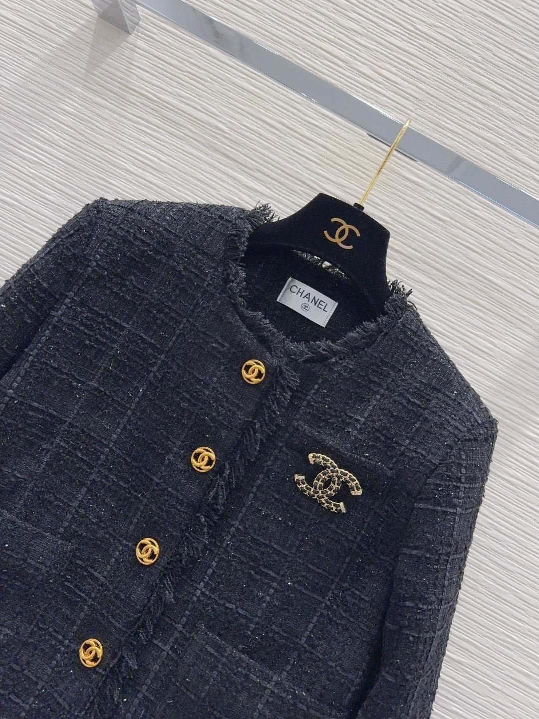 26Long-sleeved, round-neck, single-breasted jacket featuring a decorative brooch and tasseled pockets