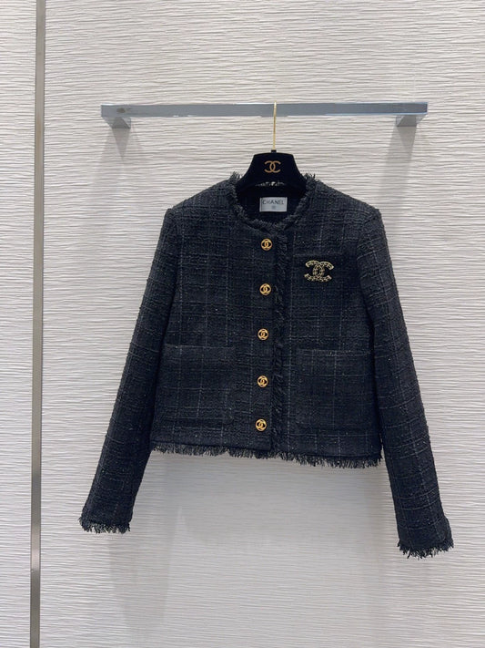 26Long-sleeved, round-neck, single-breasted jacket featuring a decorative brooch and tasseled pockets